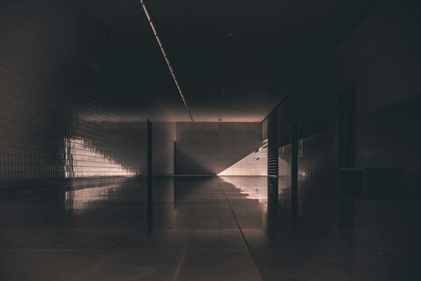 a long hallway with a light at the end of it